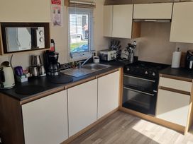A kitchen with appliances and utensils at Trecco Bay - Holiday Accommodation 20876 in Porthcawl