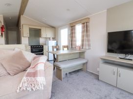 A living room with a sofa, table, and television at Cala Gran Holiday Park - Holiday Accommodation 20962, Fleetwood