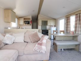 A living room with a sofa and kitchen in Cala Gran Holiday Park - Holiday Accommodation 20962 Fleetwood