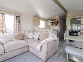 A living room with a sofa and kitchen area at Cala Gran Holiday Park - Holiday Accommodation 20962 in Fleetwood