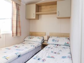A bedroom with two beds and a lamp at Cala Gran Holiday Park - Holiday Accommodation 20962 Fleetwood