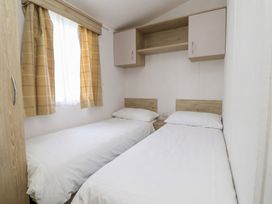 A bedroom with two single beds and a window at Ty Mawr Holiday Park - Holiday Accommodation 21121, Ty Mawr