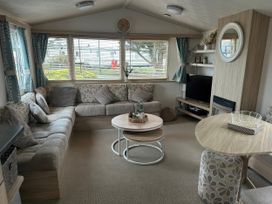 A living room with a sofa and coffee table at Greenacres Holiday Park - Holiday Accommodation 21168 Porthmadog