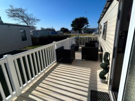 An outdoor patio with chairs and a table at Greenacres Holiday Park - Holiday Accommodation 21168 Porthmadog