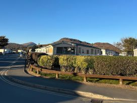 A view of holiday homes with hills in the background at Greenacres Holiday Park - Holiday Accommodation 21168 in Porthmadog