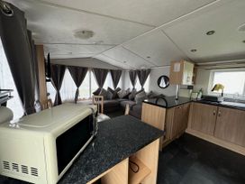 A living room with a sofa and television at Whitehouse Leisure Park - Holiday Accommodation 21355 Towyn