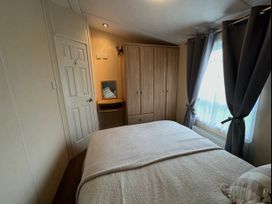 A bedroom with a bed and wardrobe at Whitehouse Leisure Park - Holiday Accommodation 21355 Towyn