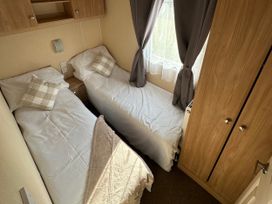 A bedroom with two single beds and a wardrobe at Whitehouse Leisure Park - Holiday Accommodation 21355 Towyn