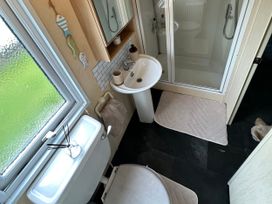 A bathroom with a sink, shower, and toilet at Whitehouse Leisure Park - Holiday Accommodation 21355 Towyn