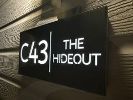 A sign displaying C43 THE HIDEOUT on a wall outside
