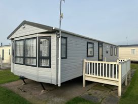 A caravan with a balcony and windows at Whitehouse Leisure Park - Holiday Accommodation 21355 Towyn