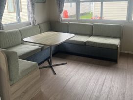 A dining area with a table and couch at Cala Gran Holiday Park - Holiday Accommodation 21402, Fleetwood