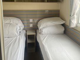 A bedroom with two beds and a bedside table at Cala Gran Holiday Park - Holiday Accommodation 21402 in Fleetwood