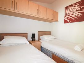 A bedroom with two beds and a lamp at St Minver Holiday Park - Holiday Accommodation 21443 Wadebridge
