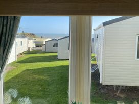 A view from a window showing holiday homes and grass at Devon Cliffs Holiday Park - Holiday Accommodation 21624 in Exmouth