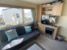 A living room with a sofa and television at Devon Cliffs Holiday Park - Holiday Accommodation 21624, Exmouth