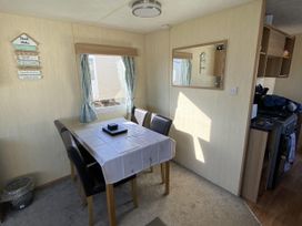 A dining area with a table and chairs at Devon Cliffs Holiday Park - Holiday Accommodation 21624 Exmouth