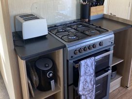 A kitchen with appliances and utensils at Devon Cliffs Holiday Park - Holiday Accommodation 21624, Exmouth