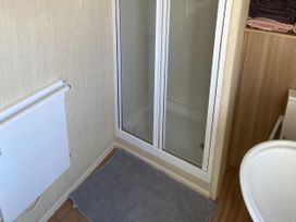 A bathroom with a shower and bath basin at Devon Cliffs Holiday Park - Holiday Accommodation 21624 Exmouth