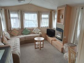 A living room with a sofa, television, and coffee table at Brightholme Holiday Park - Holiday Accommodation 21925, Brean,near Burnham On Sea