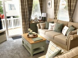 A living room with a sofa and coffee table at Aberdunant Hall Holiday Park - Holiday Accommodation 21962 Prenteg