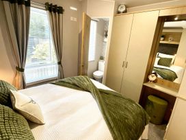 A bedroom with bed and wardrobe at Aberdunant Hall Holiday Park - Holiday Accommodation 21962 Prenteg