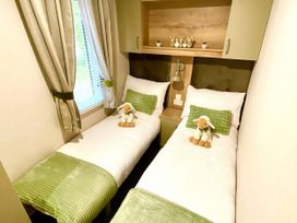 A bedroom with two beds and plush toys at Aberdunant Hall Holiday Park - Holiday Accommodation 21962, Prenteg