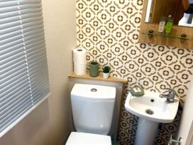 A bathroom featuring a sink, toilet, and decorative items at Aberdunant Hall Holiday Park - Holiday Accommodation 21962 Prenteg