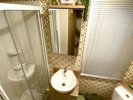 A bathroom with a shower and sink at Aberdunant Hall Holiday Park - Holiday Accommodation 21962 in Prenteg