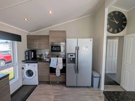 A kitchen with appliances and a washing machine at Manor Park Holiday Village - Holiday Accommodation 22030, Hunstanton