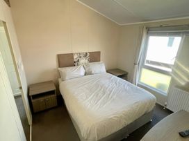 A bedroom with a double bed and nightstands at Manor Park Holiday Village - Holiday Accommodation 22030 Hunstanton