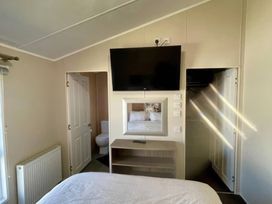 A bedroom with a bed and television at Manor Park Holiday Village - Holiday Accommodation 22030 Hunstanton