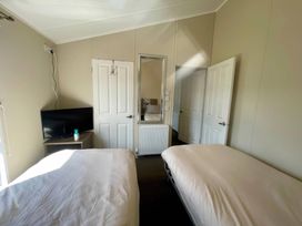 A bedroom with two beds and a television at Manor Park Holiday Village - Holiday Accommodation 22030 Hunstanton