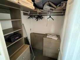 A closet with shelving and hangers at Manor Park Holiday Village - Holiday Accommodation 22030 Hunstanton