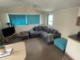 A living room with a sofa and television at Golden Gate Holiday Centre - Holiday Accommodation 22147 Towyn