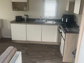 A kitchen with a sink and cooker at Golden Gate Holiday Centre - Holiday Accommodation 22147, Towyn