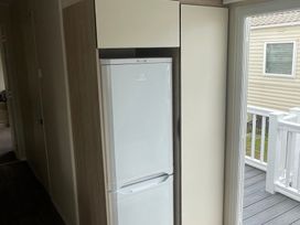A refrigerator beside a cabinet and a window at Golden Gate Holiday Centre - Holiday Accommodation 22147 Towyn