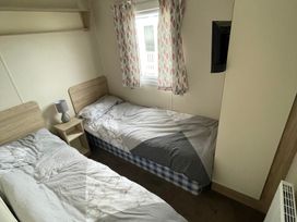 A bedroom with two beds and a window at Golden Gate Holiday Centre - Holiday Accommodation 22147 in Towyn