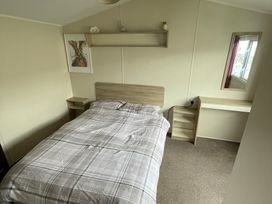A bedroom with a bed and a desk at Golden Gate Holiday Centre - Holiday Accommodation 22147 Towyn