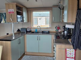 A kitchen with cabinets and appliances at Ty Gwyn Caravan Park - Holiday Accommodation 22189 Abergele