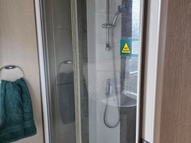A shower with a towel hanging in the bathroom at Ty Gwyn Caravan Park - Holiday Accommodation 22189 Abergele