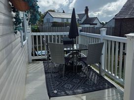 An outdoor patio with a table and chairs at Ty Gwyn Caravan Park - Holiday Accommodation 22189 Abergele