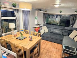 A living room with a dining table and sofa at Kingfisher Caravan Park - Holiday Accommodation 22193 Ingomells