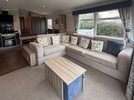 A living room with a sofa and table at Hafan y Mor Haven - Holiday Accommodation 22224, Pwllheli