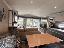 A living room with a sofa and table at Hafan y Mor Haven - Holiday Accommodation 22224 Pwllheli