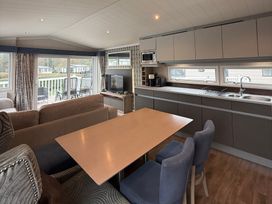 A living room with a dining table and kitchen area at Hafan y Mor Haven - Holiday Accommodation 22224 Pwllheli