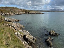 A coastal view with rocks and water at Hafan y Mor Haven - Holiday Accommodation 22224, Pwllheli