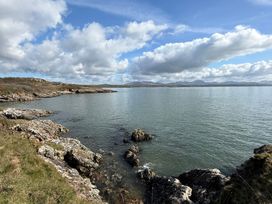 A coastal view with rocks and water at Hafan y Mor Haven - Holiday Accommodation 22224 Pwllheli