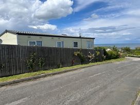 A caravan with flowers beside a fence at Newlands (private land) - Holiday Accommodation 22269 Filey