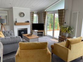 A living room with a sofa, television, and coffee table at White Acres Holiday Park - Holiday Accommodation 22327, Whitecross, Newquay